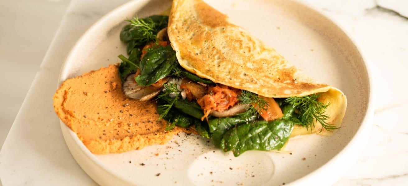 photo of the Simple Omlette folded in half with greens and cooked meat sticking out